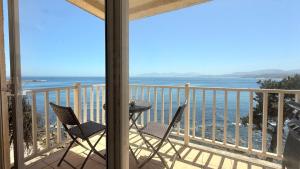 a balcony with two chairs and a view of the ocean at Departamento B84 in Puchuncaví