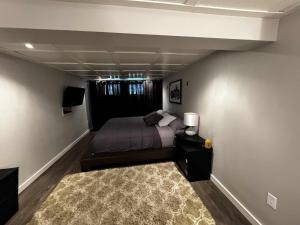 a bedroom with a bed and a rug in a room at Cottage de style Loft in Saint-Charles-des-Grondines