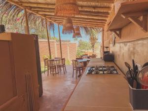 a kitchen with a stove and tables and chairs at Kinti Beach Mancora in Máncora