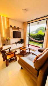 a living room with a couch and a large window at Habitación dentro de un Apartamento compartido in Ibagué