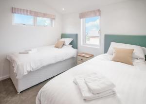 PorkellisCaddys Corner Lodges的一间卧室，配有两张床和一扇窗户