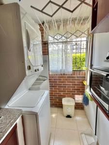 a kitchen with a white refrigerator and a window at Habitación dentro de un Apartamento compartido in Ibagué +4 photos
