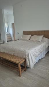 ein Schlafzimmer mit einem großen Bett und einer Holzbank in der Unterkunft Hermosa Casa De Campo en Mercedes in Mercedes + 36 Fotos