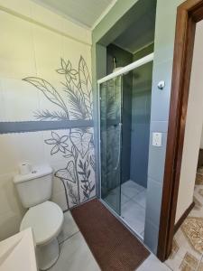Un baño con inodoro y ducha de cristal. en Villa Pachamama Hospedaria - Praia do Rosa, en Praia do Rosa