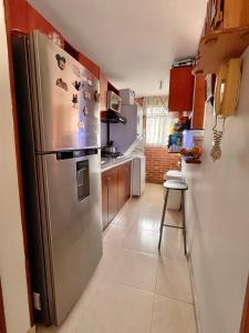 a kitchen with a stainless steel refrigerator with magnets at Habitación dentro de un Apartamento compartido in Ibagué
