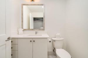 ein weißes Bad mit einem WC und einem Spiegel in der Unterkunft The Saddlery - Sound Check - 1 Block to Broadway in Nashville + 69 Fotos