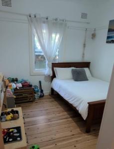 Un dormitorio con una cama y una ventana en Home in Leichhardt, Sydney, en Sídney