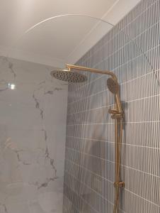 y baño con ducha y pared de piedra. en Home in Leichhardt, Sydney, en Sídney