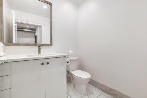 um banheiro branco com um vaso sanitário e um espelho em The Saddlery - Showroom - Walk to Broadway em Nashville mais 49 fotografias