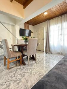 une salle à manger avec une table, des chaises et une télévision dans l'établissement Alquiler en el CENTRO Luz, à Río Gallegos