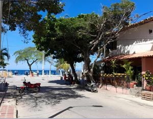 Acogedor Apto en el Rodadero في Gaira: شارع به شجرة ودراجات نارية متوقفة بجوار مبنى