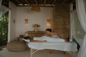 a woman laying on a bed with a child on it at Villa Cacau - Floresta in Trancoso