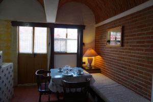 ein Esszimmer mit einem Tisch und einer Ziegelwand in der Unterkunft Suites Poza Real in Tequisquiapan