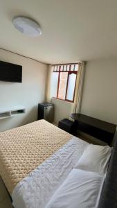 a bedroom with a large bed and a window at Habitación Matrimonial en el centro de la ciudad in Ayacucho +9 photos