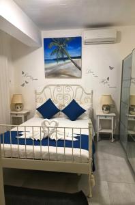 ein Schlafzimmer mit einem weißen Bett mit blauen Kissen in der Unterkunft Ducassi & Sun Beach in Punta Cana