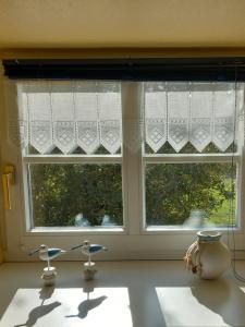 a window in a kitchen with two chairs in front of it at Mooij Plaats in Großefehn 