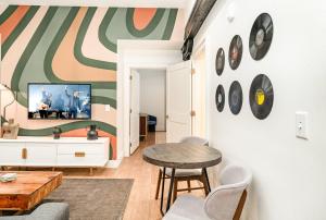 uma sala de estar com uma mesa e uma parede com relógios em The Saddlery-Playbill-4 Unit Combo-Walk 2 Broadway em Nashville