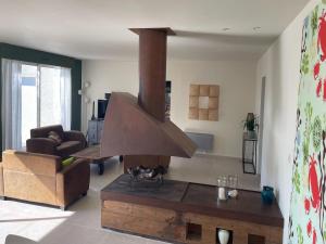 a living room with a stove in the middle of a room at Modern Villa with Pool in Brives in Brives-sur-Charente