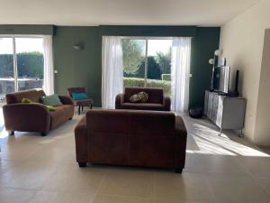 a living room with two couches and a tv at Modern Villa with Pool in Brives in Brives-sur-Charente