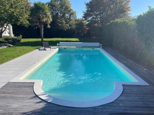 a swimming pool with a bench on a wooden deck at Modern Villa with Pool in Brives in Brives-sur-Charente