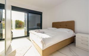 a bedroom with a large bed and a large window at Beautiful Home In Vir in Kaštelina