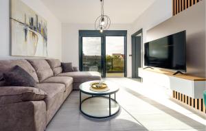 a living room with a couch and a tv at Beautiful Home In Vir in Kaštelina