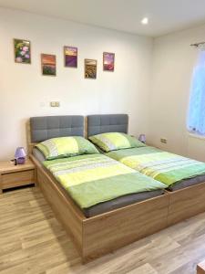 ein Schlafzimmer mit einem großen Bett mit grüner und gelber Bettwäsche in der Unterkunft Slunný domek s terasou a zahradou in Zvíkovské Podhradí