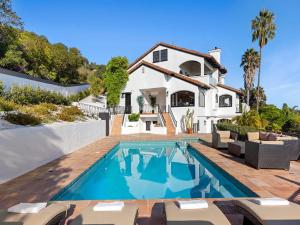 une maison avec une piscine devant une maison dans l'établissement Villa Costera, à Las Flores