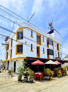 a yellow and white building with tables and umbrellas at Los Pulpos in Bombiso