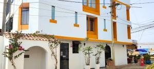 a white and orange building with plants in front of it at Los Pulpos in Bombiso