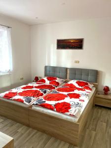 ein Schlafzimmer mit einem großen Bett mit roten und weißen Decken in der Unterkunft Slunný domek s terasou a zahradou in Zvíkovské Podhradí