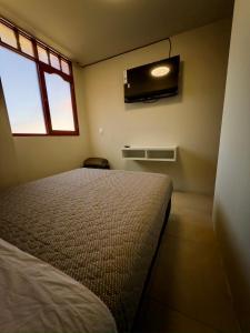 une chambre avec un lit et une télévision au mur dans l'établissement Habitación privada en el centro de la ciudad, à Ayacucho 6 autres photos