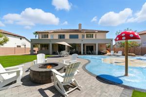 een patio met stoelen en een parasol naast een zwembad bij Splash Canyon - Splash Pad & Tons of Games - Gym in Chandler