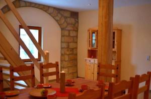 ein Esszimmer mit einem Tisch und einer Steinwand in der Unterkunft Ferienhaus in Naundorf mit Grill und Terrasse - b53704 in Struppen