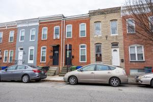 due auto parcheggiate di fronte a un edificio di mattoni di CityStay a Baltimora