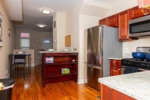 una cucina con frigorifero in acciaio inox e mobili in legno di CityStay a Baltimora