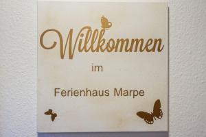 un panneau pour une auberge du millénaire avec des papillons dessus dans l'établissement Schönes Ferienhaus Am Twistesee, à Bad Arolsen