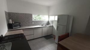 Departamento LUNA NUEVA في سانتا كلارا ديل مار: مطبخ صغير مع ثلاجة ومغسلة +6 صور