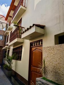 ein Haus mit einer Holztür und einem Balkon in der Unterkunft Departamento completo en el primer piso in Ayacucho