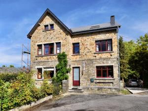 une maison en briques avec une porte rouge dans l'établissement Villa with Spa, Luxembourg, à Érezée
