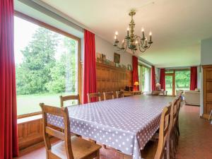 a dining room with a table and a large window at Rustic Retreat in Houvegné in Houvegné