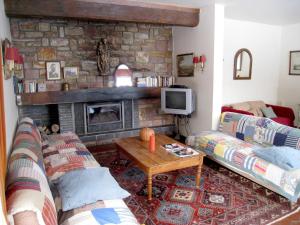 a living room with two couches and a fireplace at Rustic Retreat in Houvegné in Houvegné