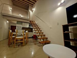 a room with a staircase with a table and chairs at Departamento Studio 20 - Rio Grande - Tierra del Fuego in Río Grande