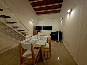 a dining room with a table and chairs and stairs at Departamento Studio 20 - Rio Grande - Tierra del Fuego in Río Grande
