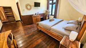 a bedroom with a large bed and wooden floors at Ananda B&B in Gili Air