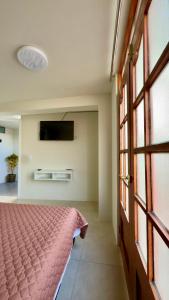 a bedroom with a bed and a flat screen tv at Habitación con Balcón Castellares La Puebla in Ayacucho