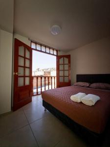 a bedroom with a bed and a large window at Habitación con Balcón Castellares La Puebla in Ayacucho