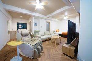 un salon avec un siège auto et une télévision dans l'établissement Miyazaki Mango Hotel - Vacation STAY 58309v, à Miyazaki