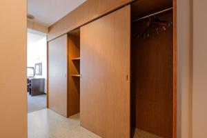 Cette chambre comprend un placard avec une porte en bois. dans l'établissement Miyazaki Mango Hotel - Vacation STAY 58300v, à Miyazaki