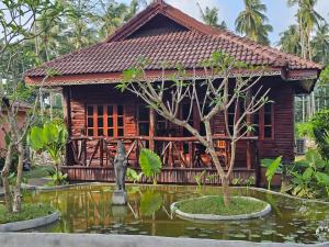 a wooden house with a pond in front of it at ลันตาไวท์ร็อก รีสอร์ท in Ban Nong Chaeng +15 photos